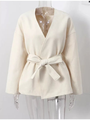 Chic beige surplice trench coat with tie waist and dropped shoulders.