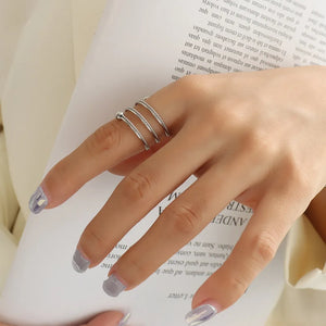 Silver spiral orb ring with twisted bands and a small bead detail.