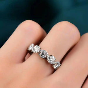 Silver moissanite eternity wave ring with clear round-cut stones.