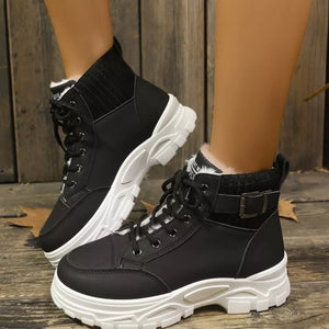 Black lace-up combat boots with white chunky soles and faux fur trim.