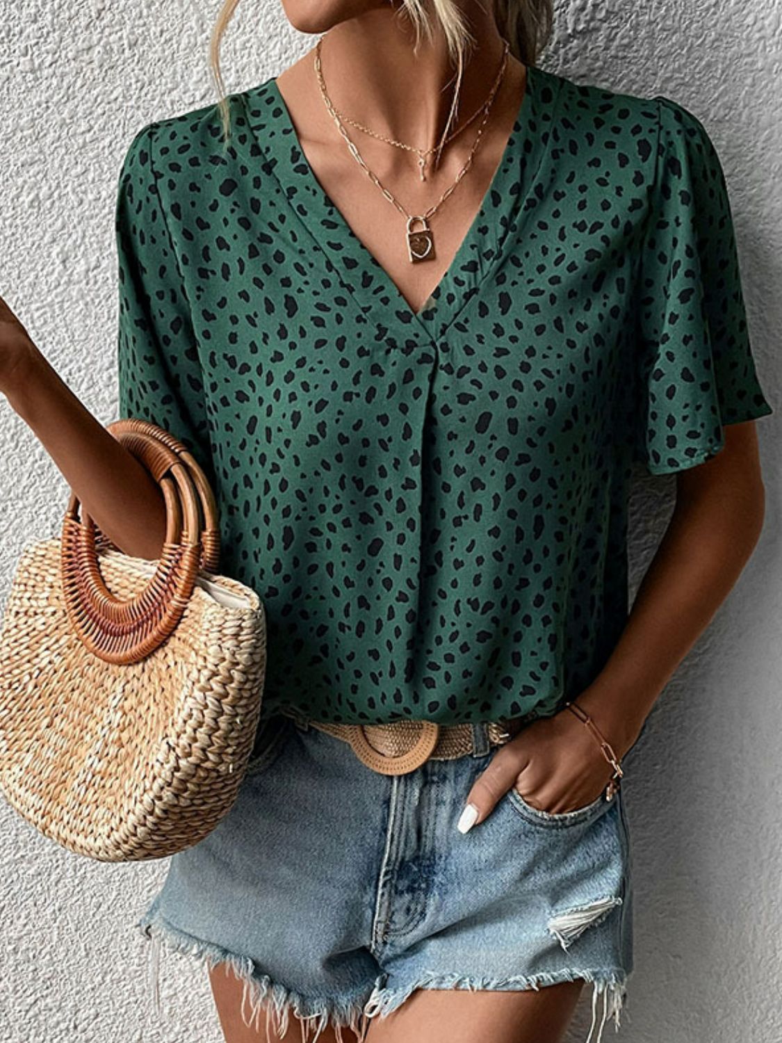 Emerald leopard print V-neck blouse with short flutter sleeves and a relaxed fit.