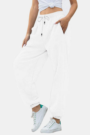 Relaxed-fit white sweatpants with cuffed ankles and drawstring waist.