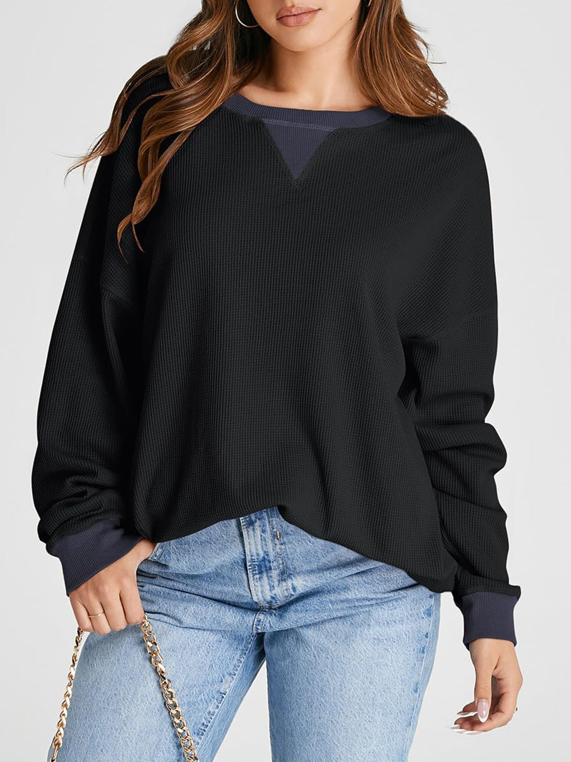 Black waffle knit raglan sleeve sweatshirt with contrast V-neck detail and navy cuffs.