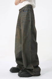 Faded oversized denim trousers in dark wash, featuring a relaxed fit and wide leg.