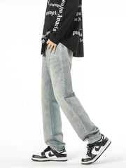 Light wash denim jeans with a loose fit and vintage wash, worn by a man.