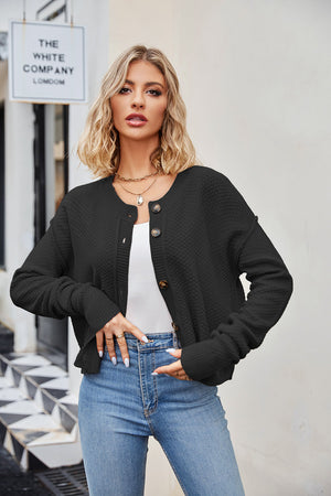 Black textured knit cropped cardigan with button front and crew neck.