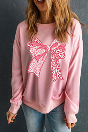 Blush pink crewneck sweatshirt with a large pink leopard print bow graphic on the front.