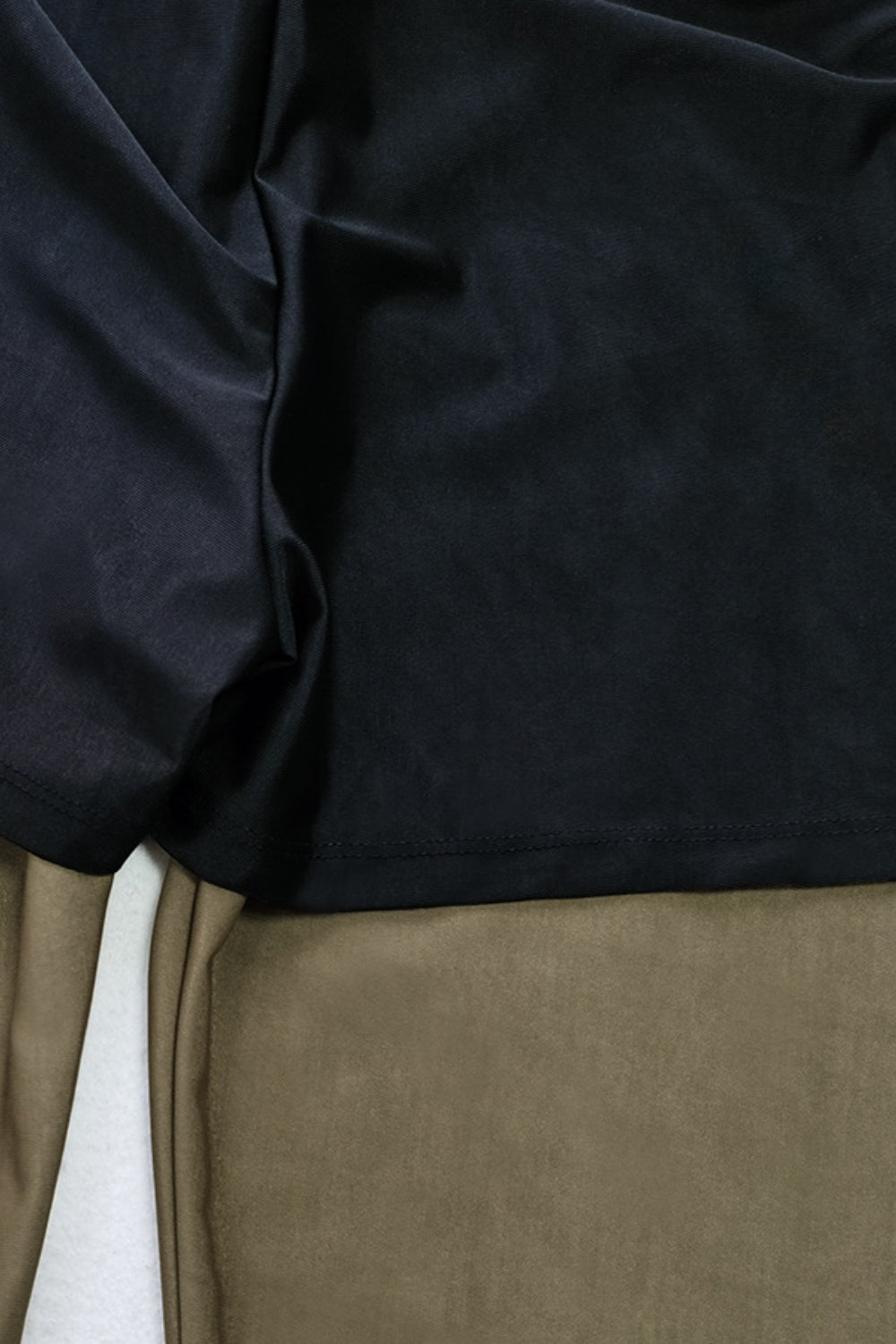 Black sporty legging swimsuit with zip detail shown up close.