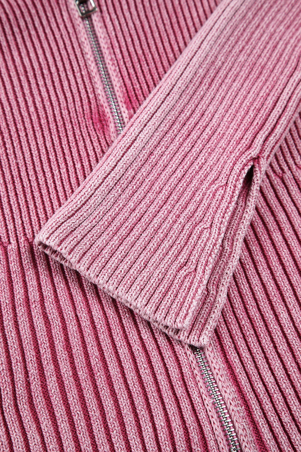 Pink ribbed knit top with flare sleeves and a zipper detail.