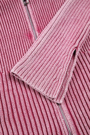 Pink ribbed knit top with flare sleeves and a zipper detail.