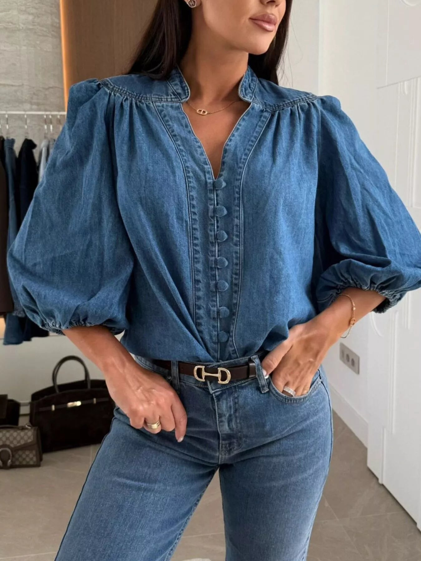 Denim button-down blouse with puff sleeves and a V-neckline in dark blue.