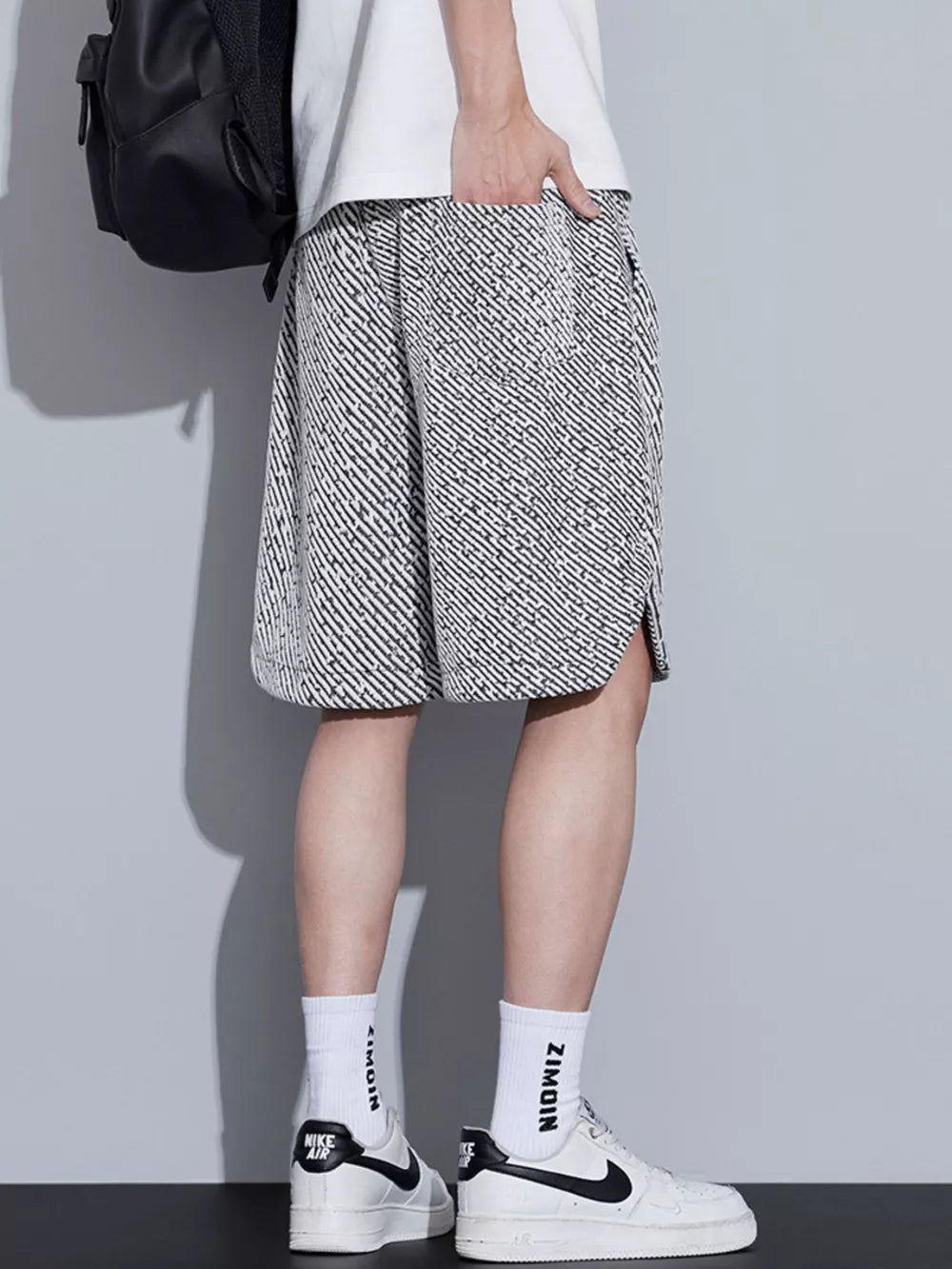 Men's boxer shorts in black and white abstract pattern with drawstring and side slits.
