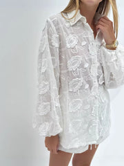 White embroidered two-piece shirt and shorts set with sheer fabric and balloon sleeves.