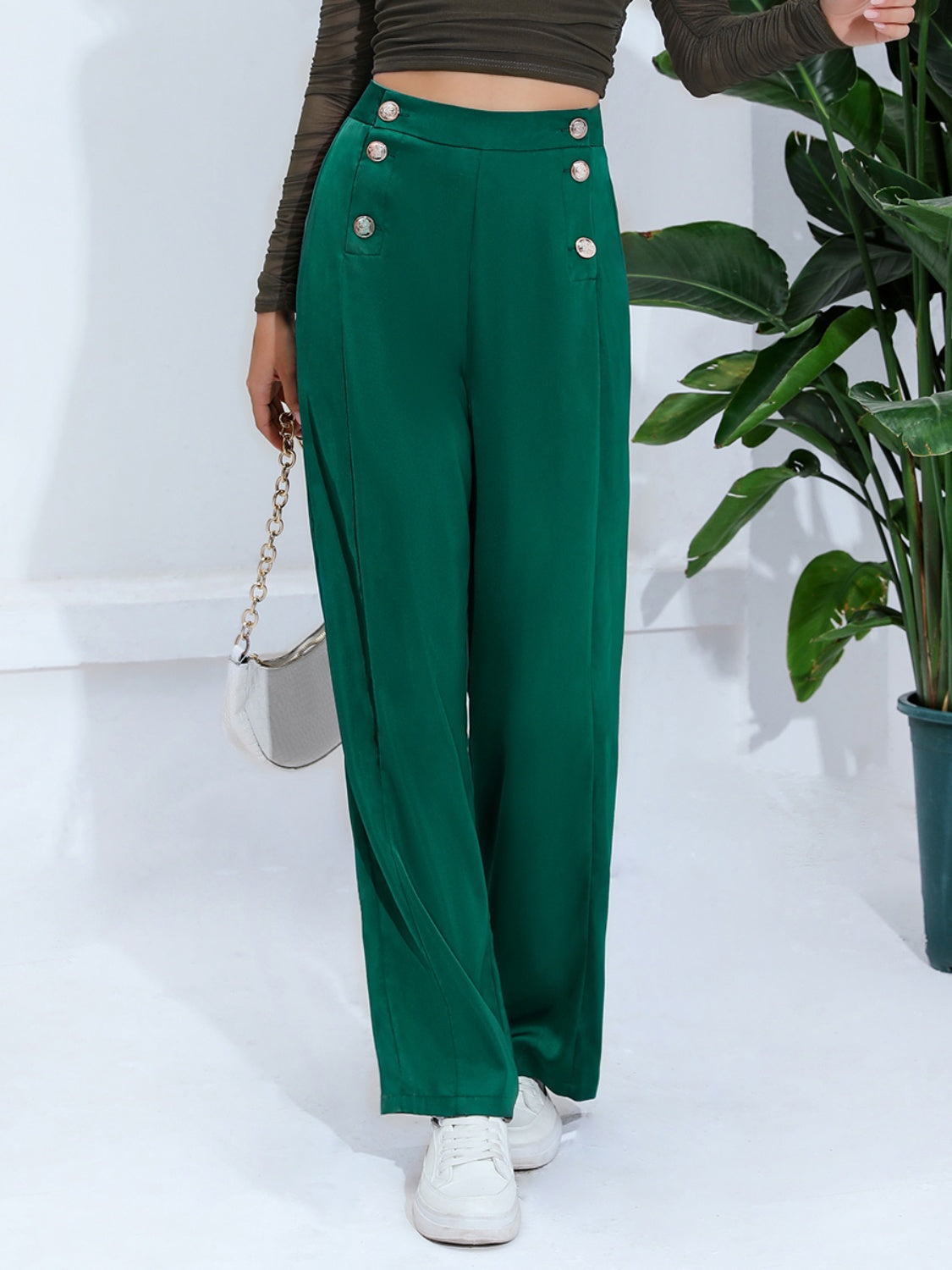 Dark green wide-leg trousers with nautical button detail and high waist.