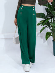Dark green wide-leg trousers with nautical button detail and high waist.