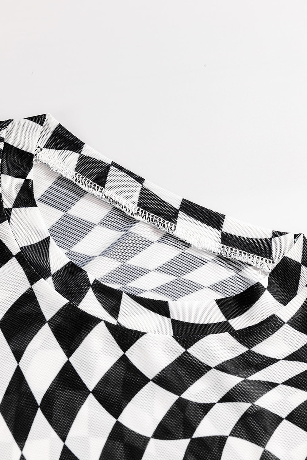 Black and white checkered mesh blouse with a crew neck and visible stitching detail.