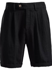 Black pleated chino shorts with button closure and cuffed hems.