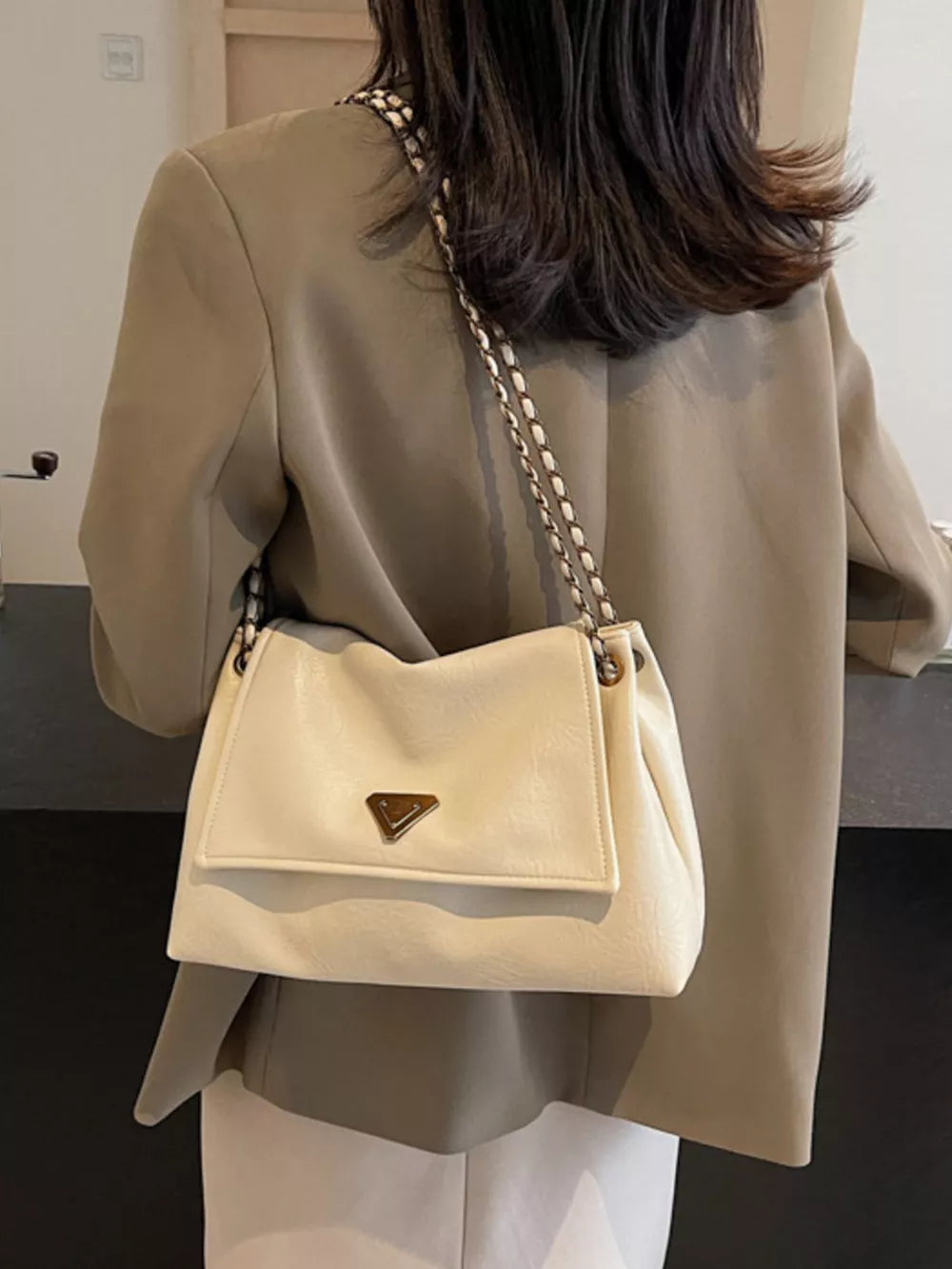 Off-white shoulder bag with chain detail and triangle logo clasp