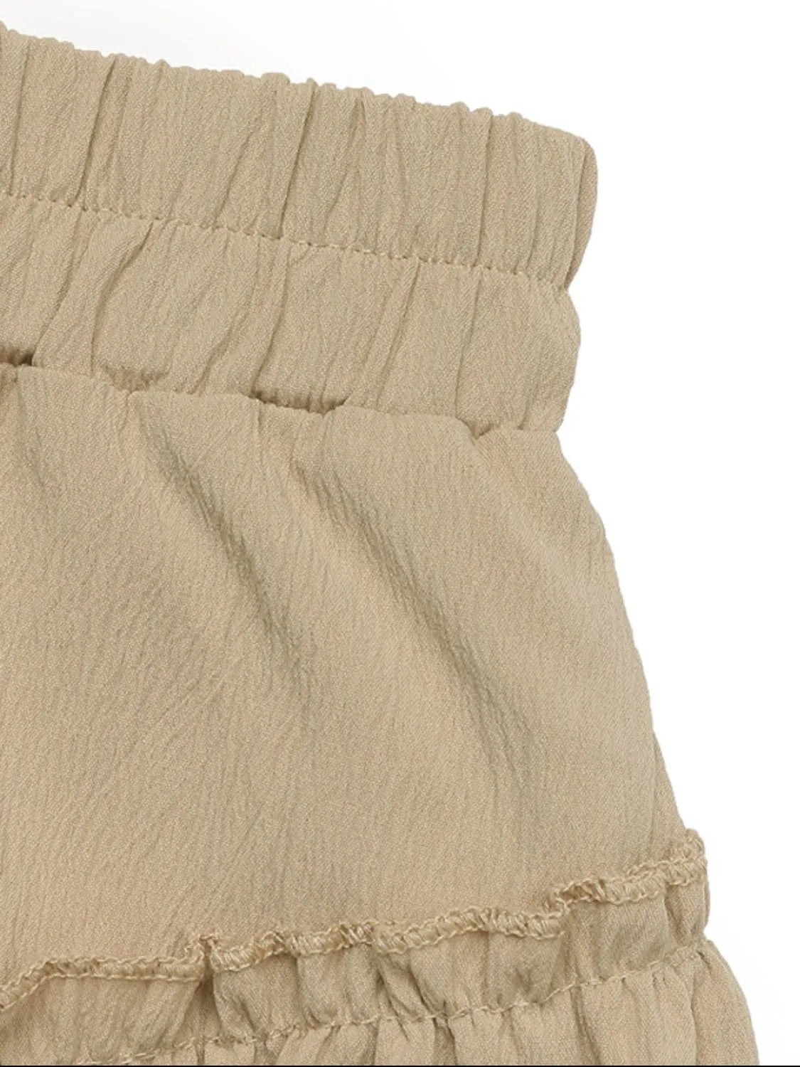 Tiered ruffle mini skirt in tan with elastic waistband and textured fabric.