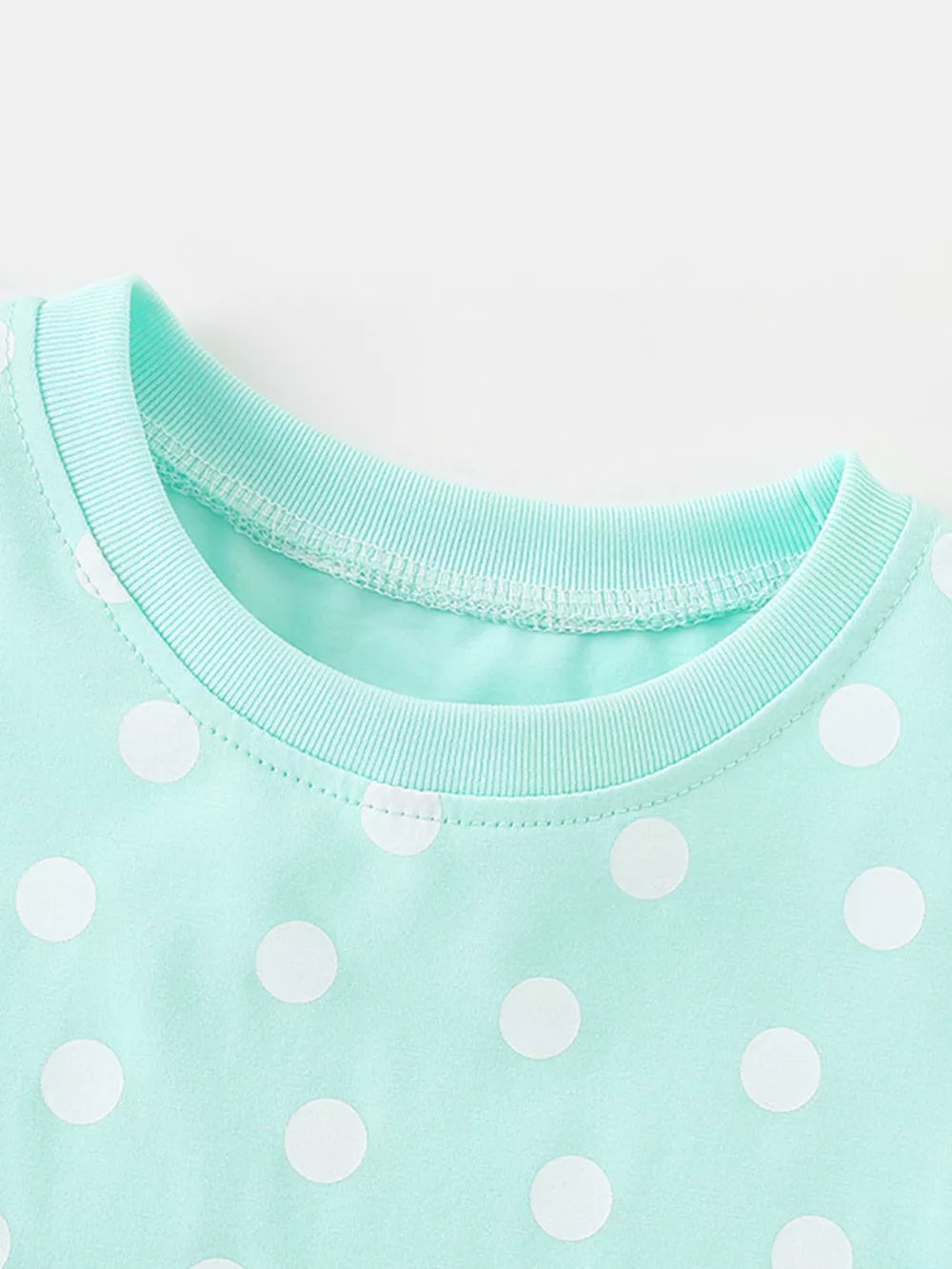 Baby dress with white polka dots on a mint green cotton blend fabric, crew neck.