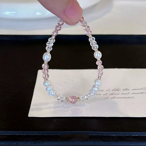 Delicate pearl and crystal bracelet with pink beads and a central pink stone.