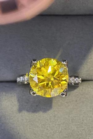 Silver solitaire ring with a bright yellow canary diamond and small accent stones.