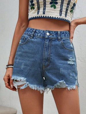 Distressed denim shorts in medium wash with frayed hem and ripped details.