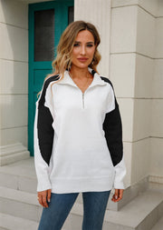 Colorblock zip-neck knit pullover sweater in white with black sleeves and shoulders.