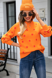 Orange polka dot knit sweater with balloon sleeves and mock neck, styled with jeans.