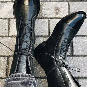 Black leather ankle boots with glossy cap toes and lace-up front.