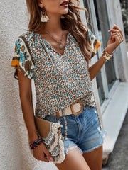 Bohemian floral print blouse with flutter sleeves and V-neck.