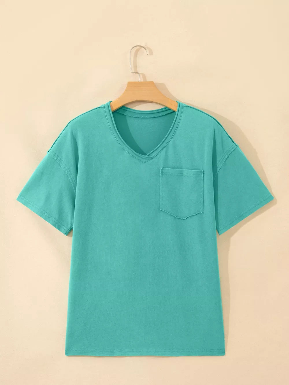 Teal mineral wash cotton v-neck t-shirt with chest pocket and raw hem detail.