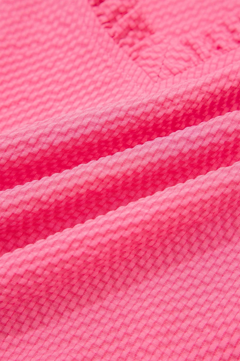 Women's pink textured embroidered blouse with a subtle diamond pattern.