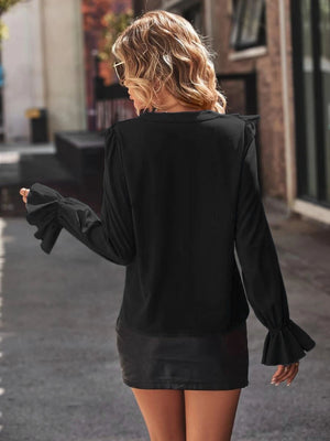 Black polyester blouse with ruffled shoulders and bell sleeves.