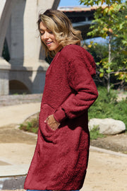 Plush hooded duster in deep red with thumbhole cuffs and pockets.