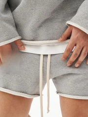Gray fleece lounge shorts with raw edge hem and drawstring.