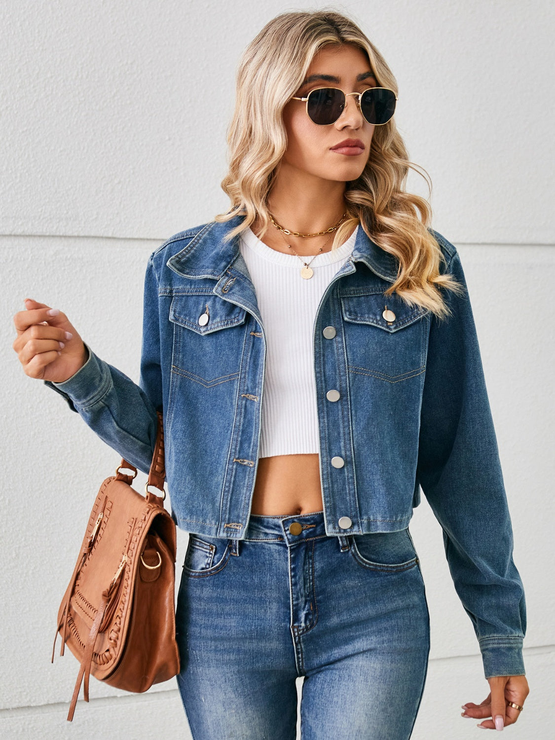 Cropped denim trucker jacket in dusty blue with button details and a white crop top.