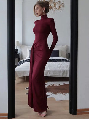 Burgundy turtleneck maxi dress with long sleeves and draped tie detail.