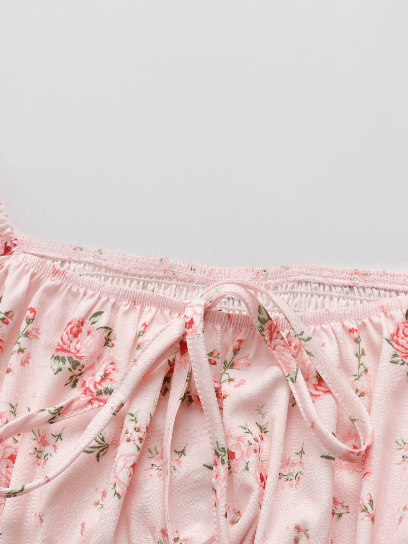 Pink floral tie front blouse with smocked neckline and puff sleeves.