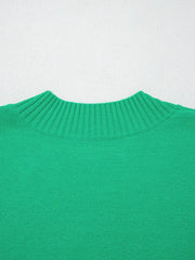 Green ribbed knit top with ruffled round neck and textured detail.