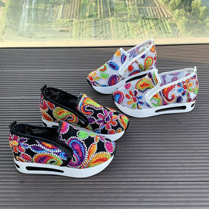 Paisley print platform slip-on shoes in white and black with chunky soles.