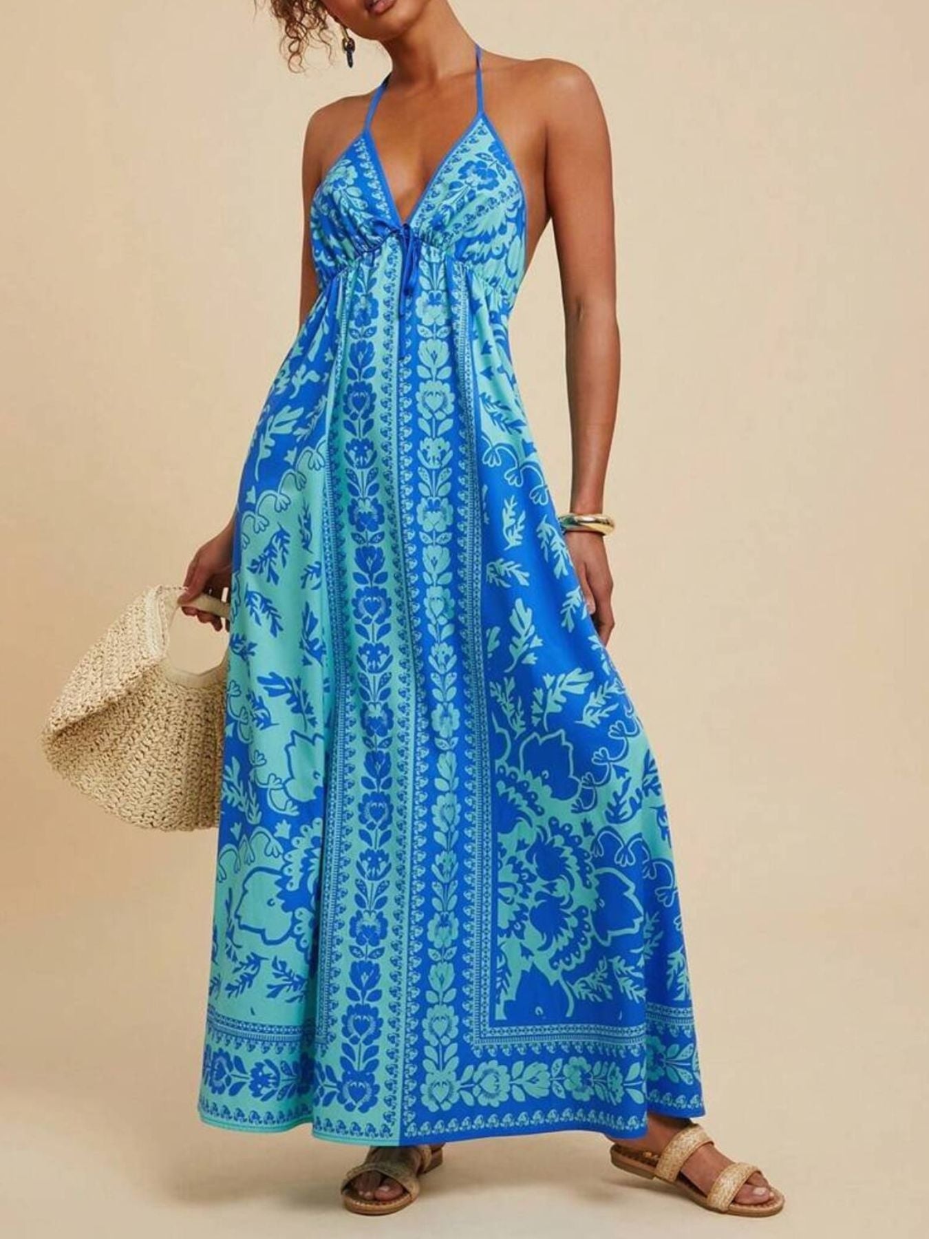 Blue floral halter maxi dress with plunging neckline and tie detail.