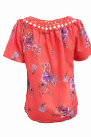 Coral floral blouse with crochet yoke and short sleeves.