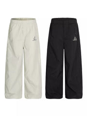 Men's wide-leg sweatpants in gray and black with crinkled texture and logo detail.