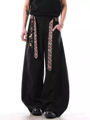 Black wide-leg sweatpants with plaid straps and chain detail.