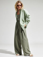 Light green textured cotton overshirt with relaxed fit and button front, styled with wide-leg pants.