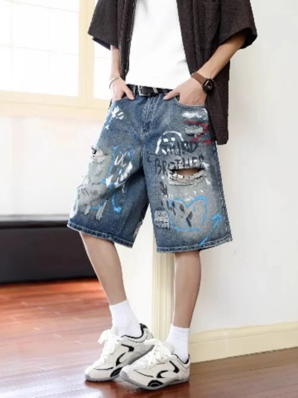 Men's distressed blue denim shorts with graffiti print and ripped details