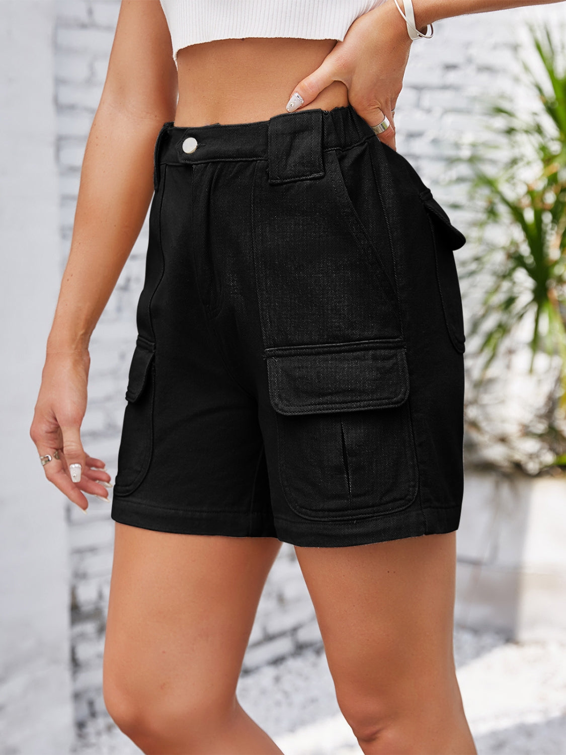 Black denim high-waist cargo shorts with multiple utility pockets.
