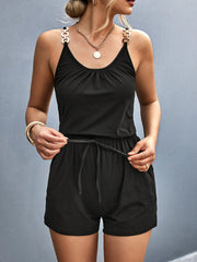 Black chain-strap drawstring romper with gathered neckline and tie waist.