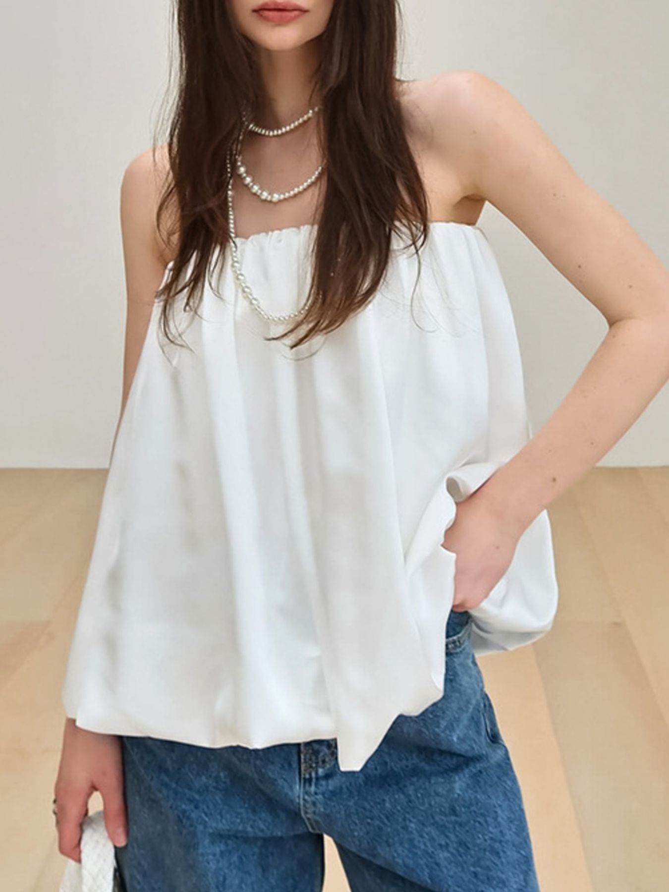 White strapless bubble hem top with gathered neckline, styled with pearls